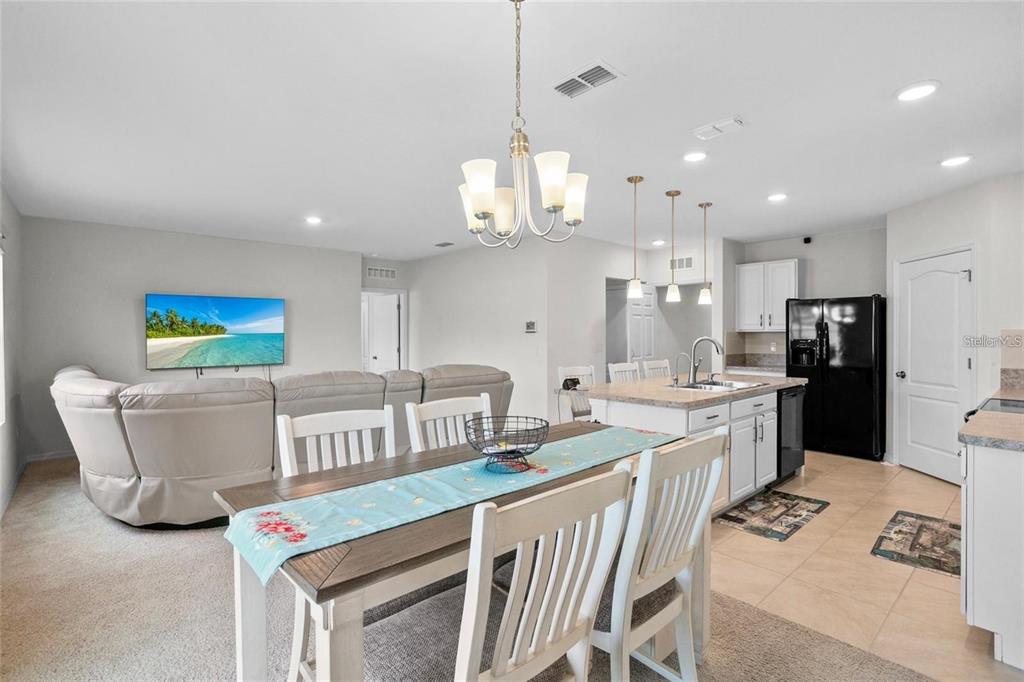 1872 Rustic Falls Drive Kissimmee, FL 34744 - Photo 14 of 30 a kitchen with stainless steel appliances granite countertop a stove a sink dishwasher a refrigerator and white cabinets with wooden floor