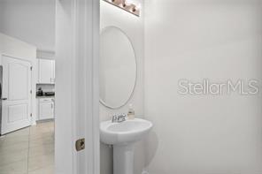 1872 Rustic Falls Drive Kissimmee, FL 34744 - Photo 18 of 30 a bathroom with a sink a mirror and shower