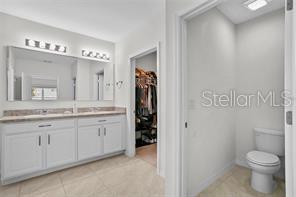 1872 Rustic Falls Drive Kissimmee, FL 34744 - Photo 20 of 30 a bathroom with a granite countertop sink toilet and shower