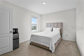 1872 Rustic Falls Drive Kissimmee, FL 34744 - Photo 21 of 30 a bedroom with a bed and a refrigerator