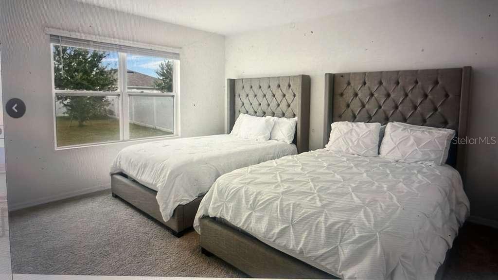 1872 Rustic Falls Drive Kissimmee, FL 34744 - Photo 22 of 30 a bedroom with two beds and a large window