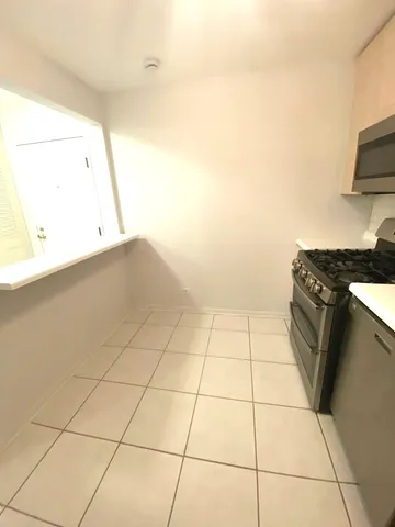a kitchen with a white cabinets and a stove top oven