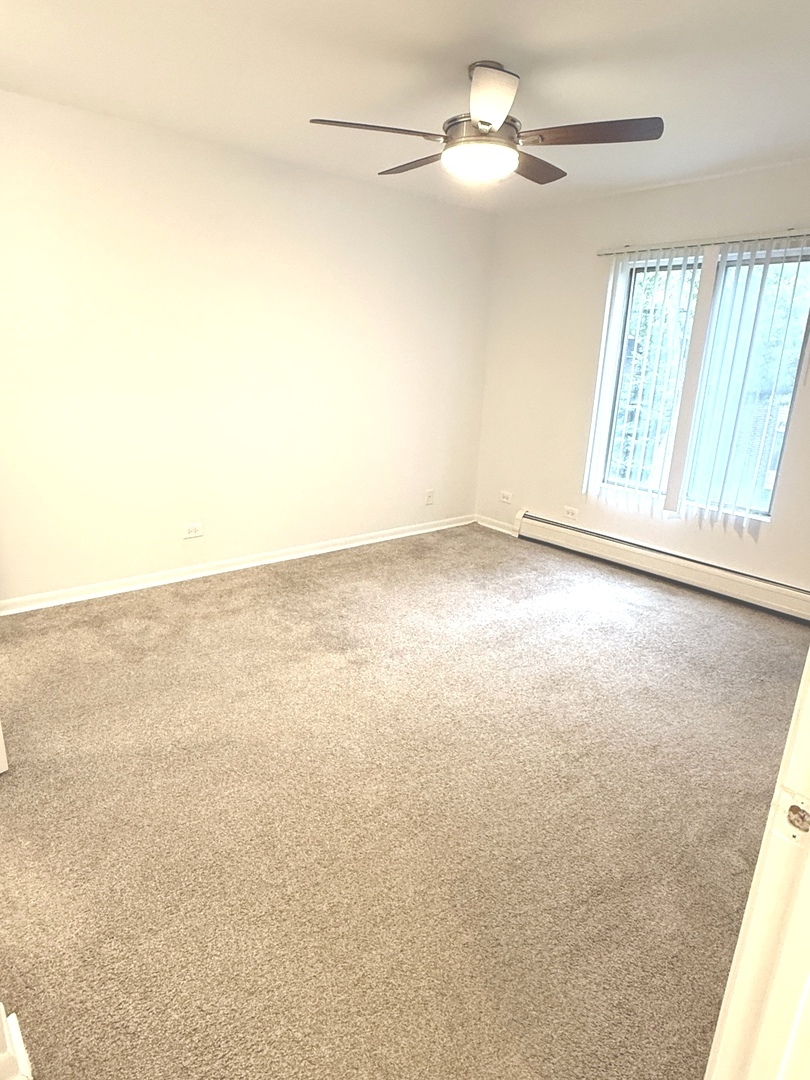 1149 Miller Lane, Unit 212 Buffalo Grove, IL 60089 - Photo 15 of 20 an empty room with windows and fan