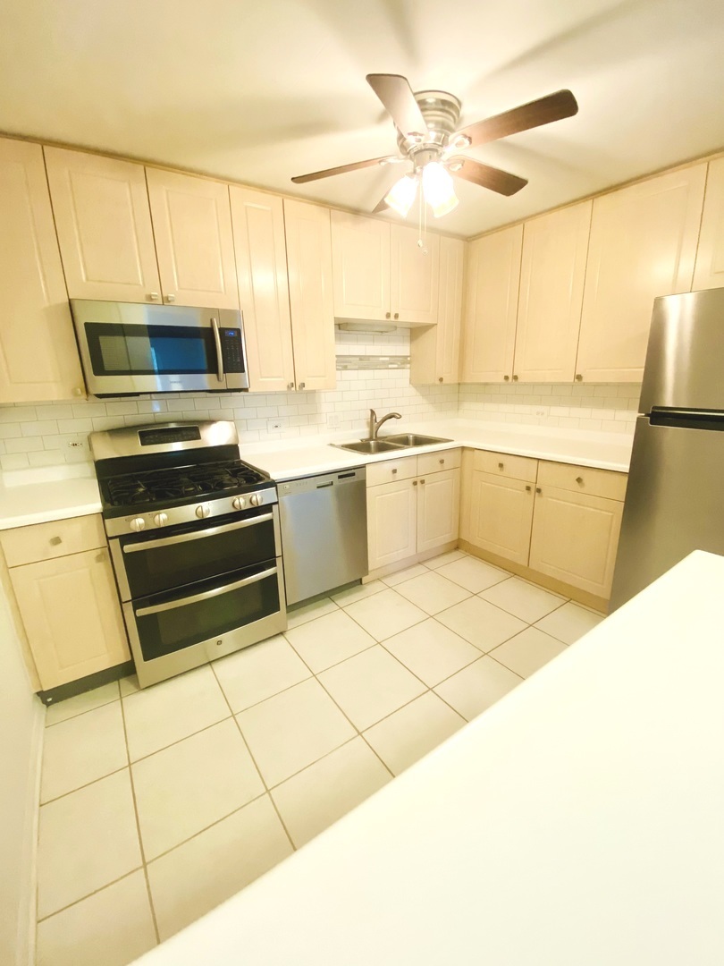 1149 Miller Lane, Unit 212 Buffalo Grove, IL 60089 - Photo 7 of 20 a kitchen with stainless steel appliances a stove a sink and a refrigerator
