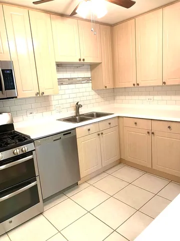a kitchen with a sink a stove and cabinets