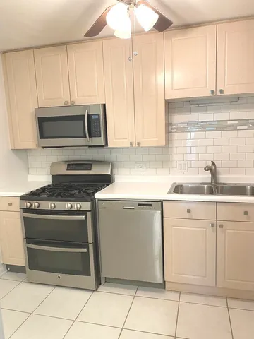 a kitchen with cabinets stainless steel appliances and a sink