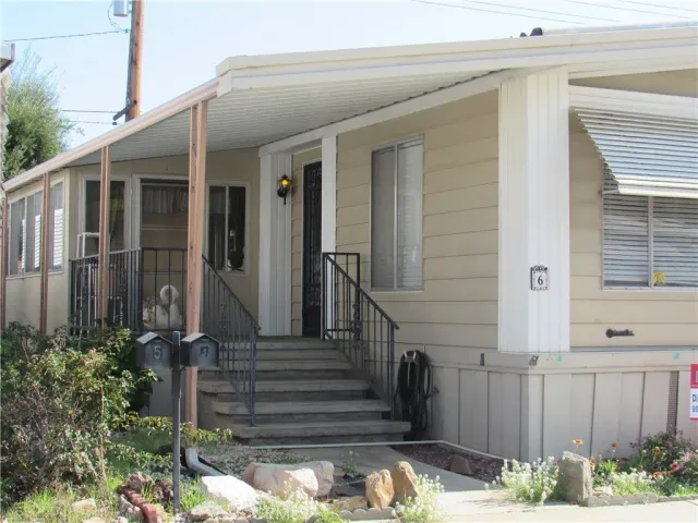 a view of a house with a small yard and wooden floor and fence