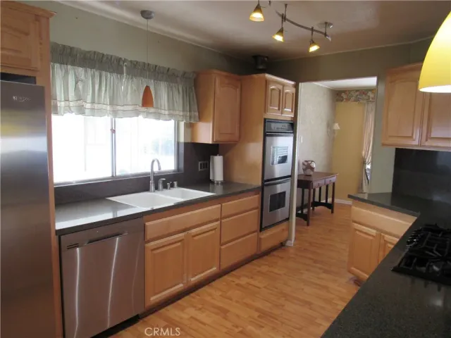 a kitchen with stainless steel appliances granite countertop a sink stove and refrigerator