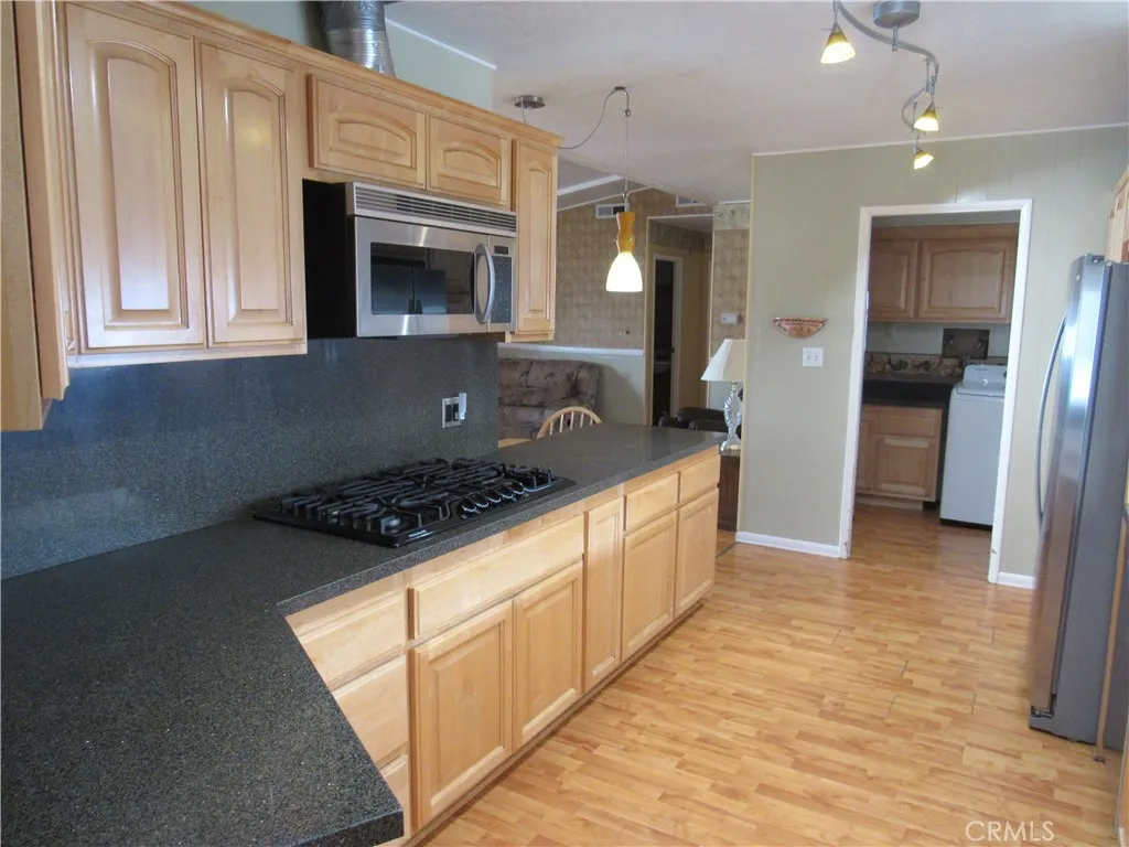 27701 Murrieta Road, Unit 6 Menifee, CA 92586 - Photo 15 of 28 a kitchen with stainless steel appliances granite countertop a stove a sink and a refrigerator