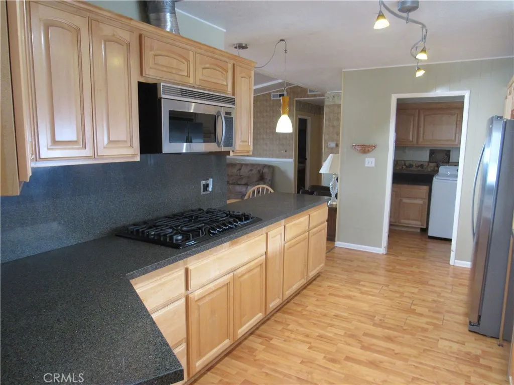 27701 Murrieta Road, Unit 6 Menifee, CA 92586 - Photo 15 of 28 a kitchen with stainless steel appliances granite countertop a stove a sink and a refrigerator