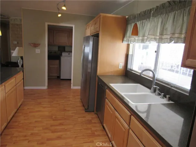 a kitchen with stainless steel appliances granite countertop a sink and a refrigerator