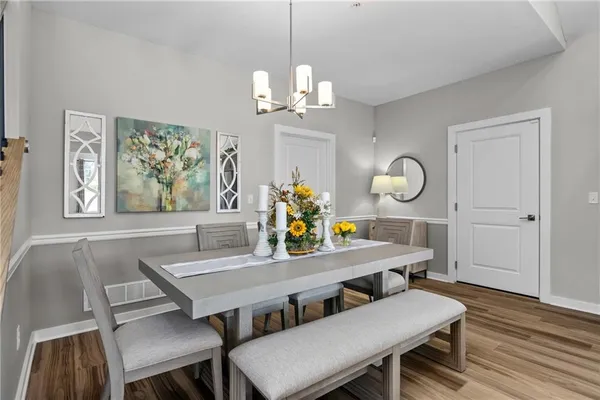 a view of a dining room with furniture a chandelier and wooden floor