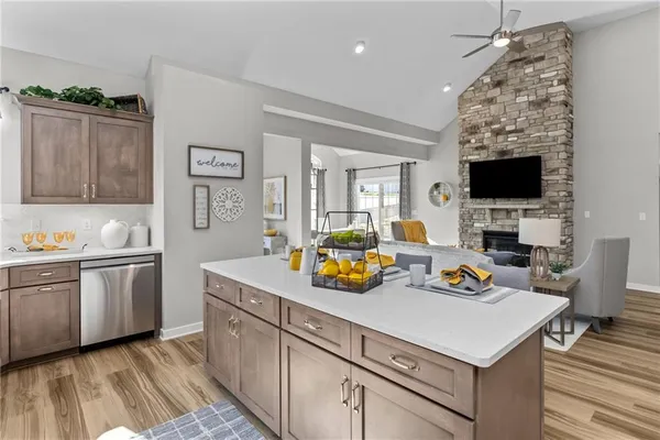 a utility room with stainless steel appliances granite countertop a sink a stove and a wooden floors