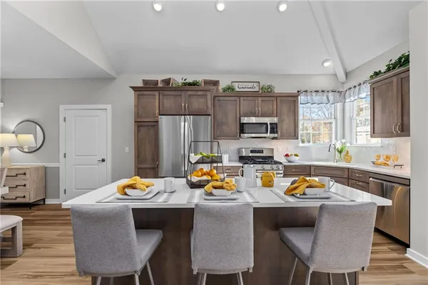 a view of a dining room with furniture a kitchen and chandelier