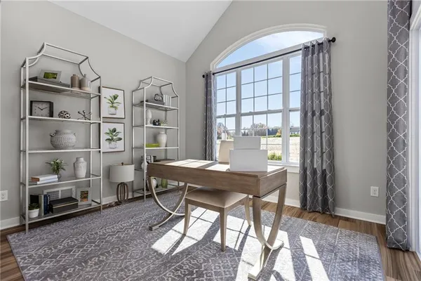 a view of a workspace with furniture and a window