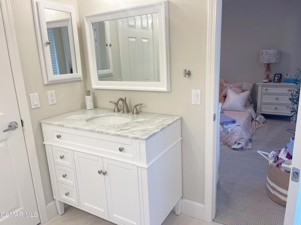 2437 Whitechapel Place Thousand Oaks, CA 91362 - Photo 28 of 36 a bathroom with a granite countertop sink and a mirror