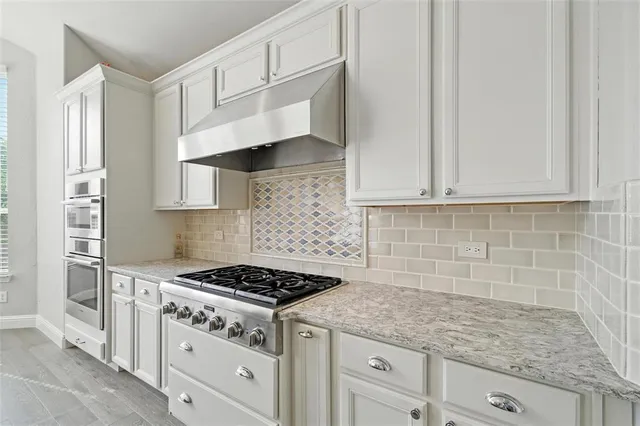 a kitchen with kitchen island white cabinets and stainless steel appliances