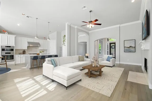 a living room with furniture kitchen view and a chandelier