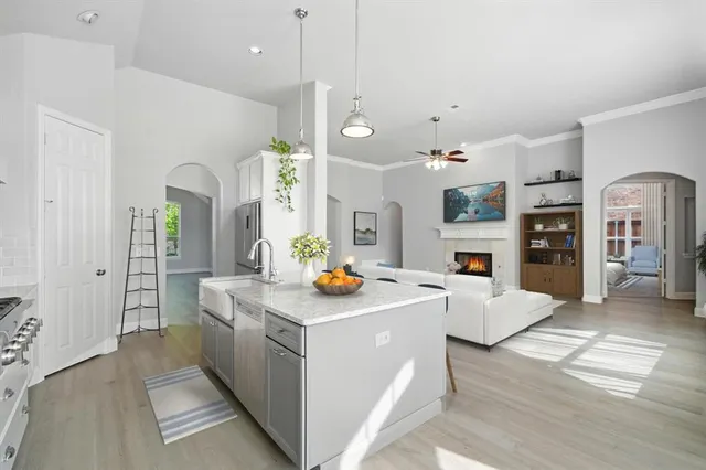 a view of living room with stainless steel appliances furniture a fireplace and a open kitchen view