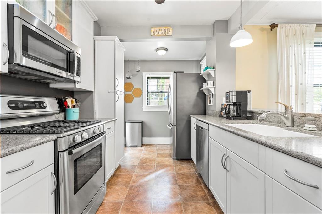 416 Maple Avenue Pittsburgh, PA 15215 - Photo 11 of 38 a kitchen with stainless steel appliances granite countertop a stove a sink and a microwave