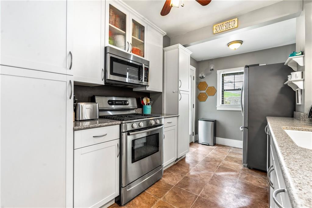 416 Maple Avenue Pittsburgh, PA 15215 - Photo 12 of 38 a kitchen with stainless steel appliances granite countertop a stove a sink and a refrigerator
