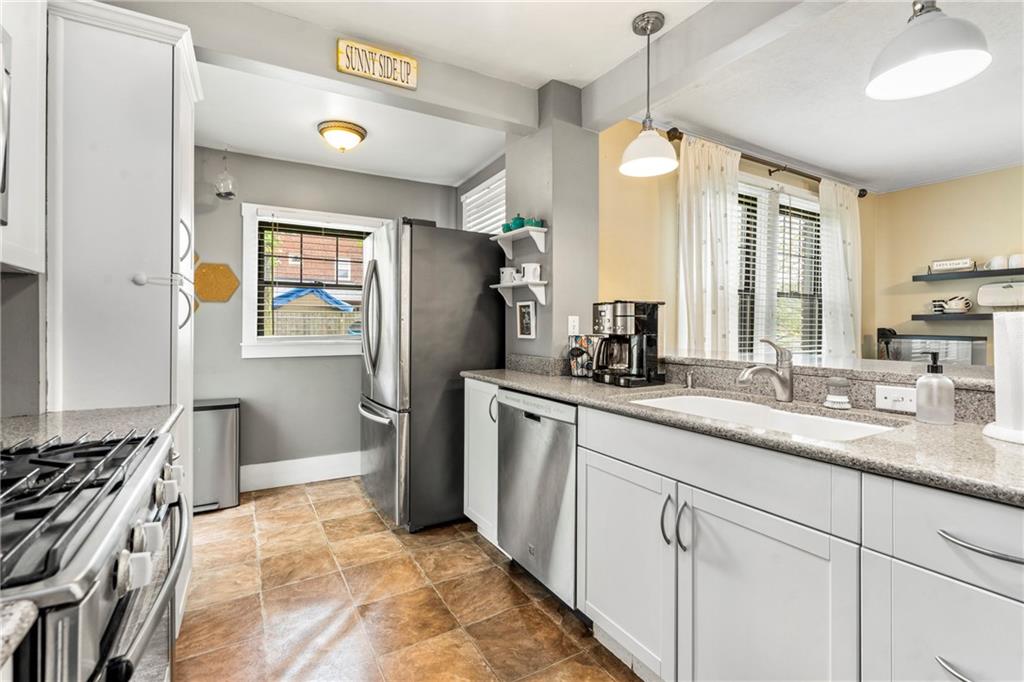 416 Maple Avenue Pittsburgh, PA 15215 - Photo 13 of 38 a kitchen with stainless steel appliances granite countertop a sink a stove a refrigerator a center island and cabinets