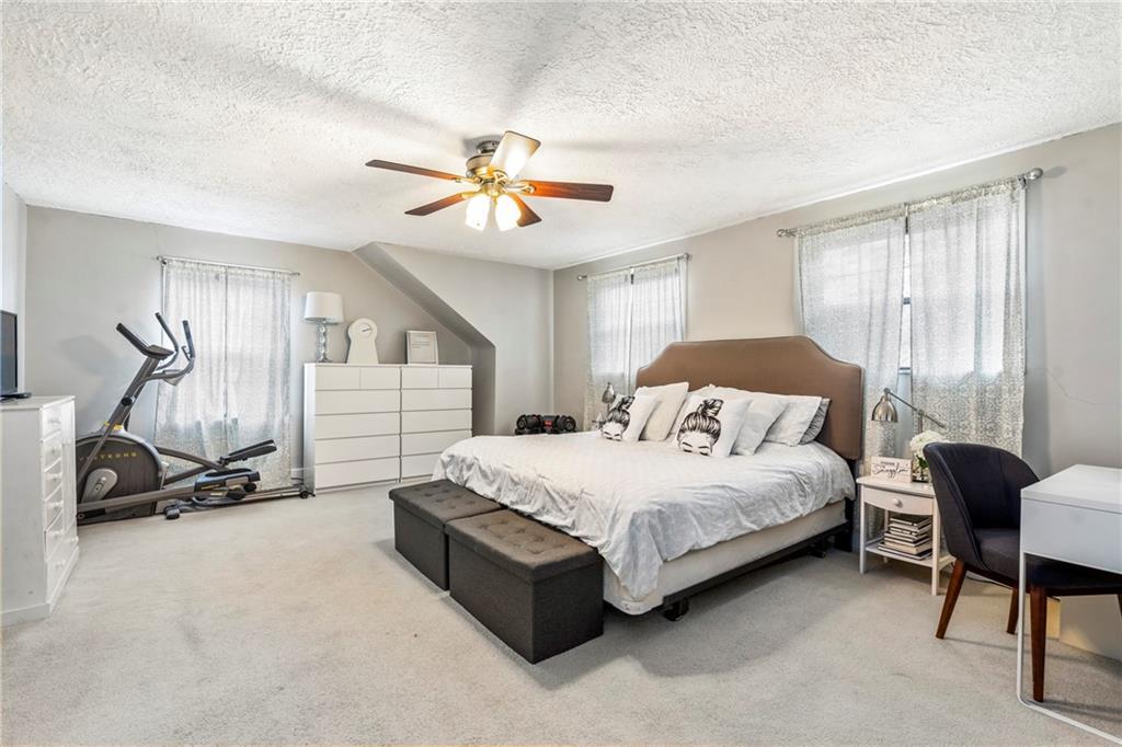 416 Maple Avenue Pittsburgh, PA 15215 - Photo 18 of 38 a spacious bedroom with a bed a chair and a chandelier