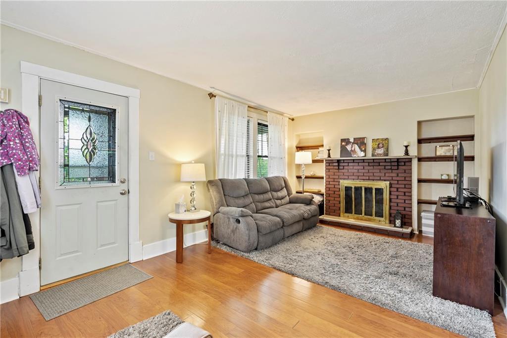416 Maple Avenue Pittsburgh, PA 15215 - Photo 6 of 38 a living room with furniture a flat screen tv and a fireplace
