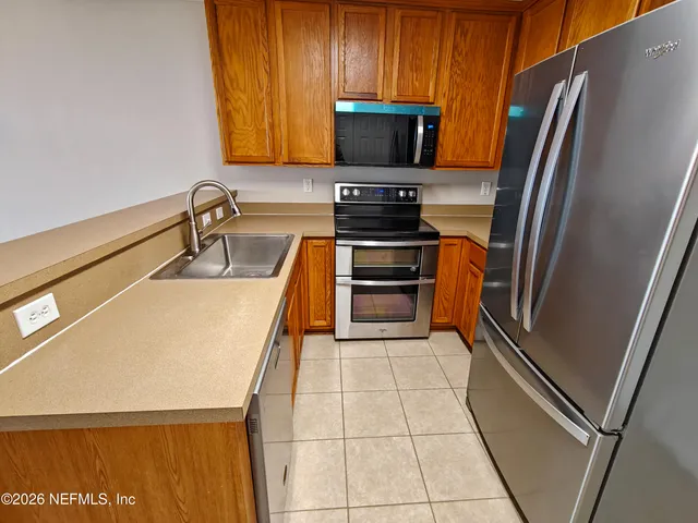 an empty room with a chandelier fan and windows
