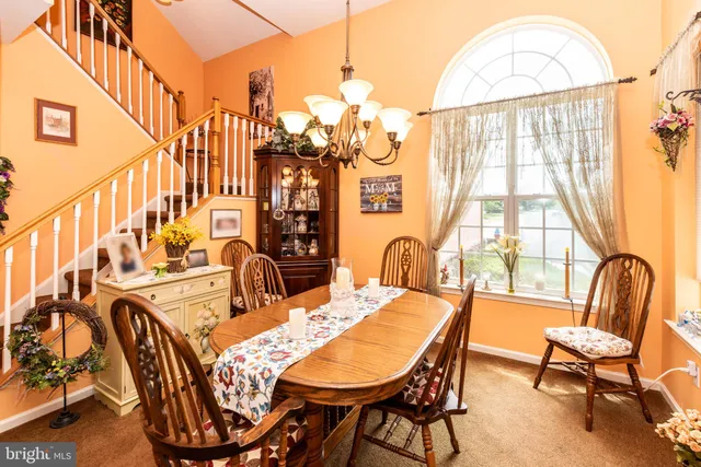 a dining room with furniture a chandelier and wooden floor
