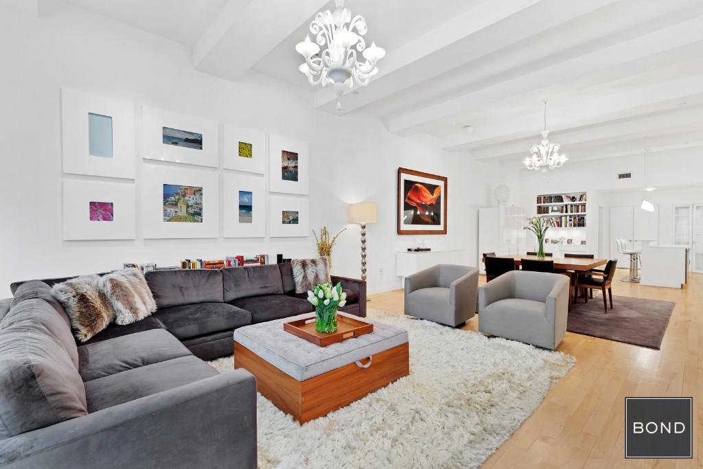 15 Broad Street, Unit 916 Manhattan, NY 10005 - Photo 1 of 1 a living room with furniture and a chandelier