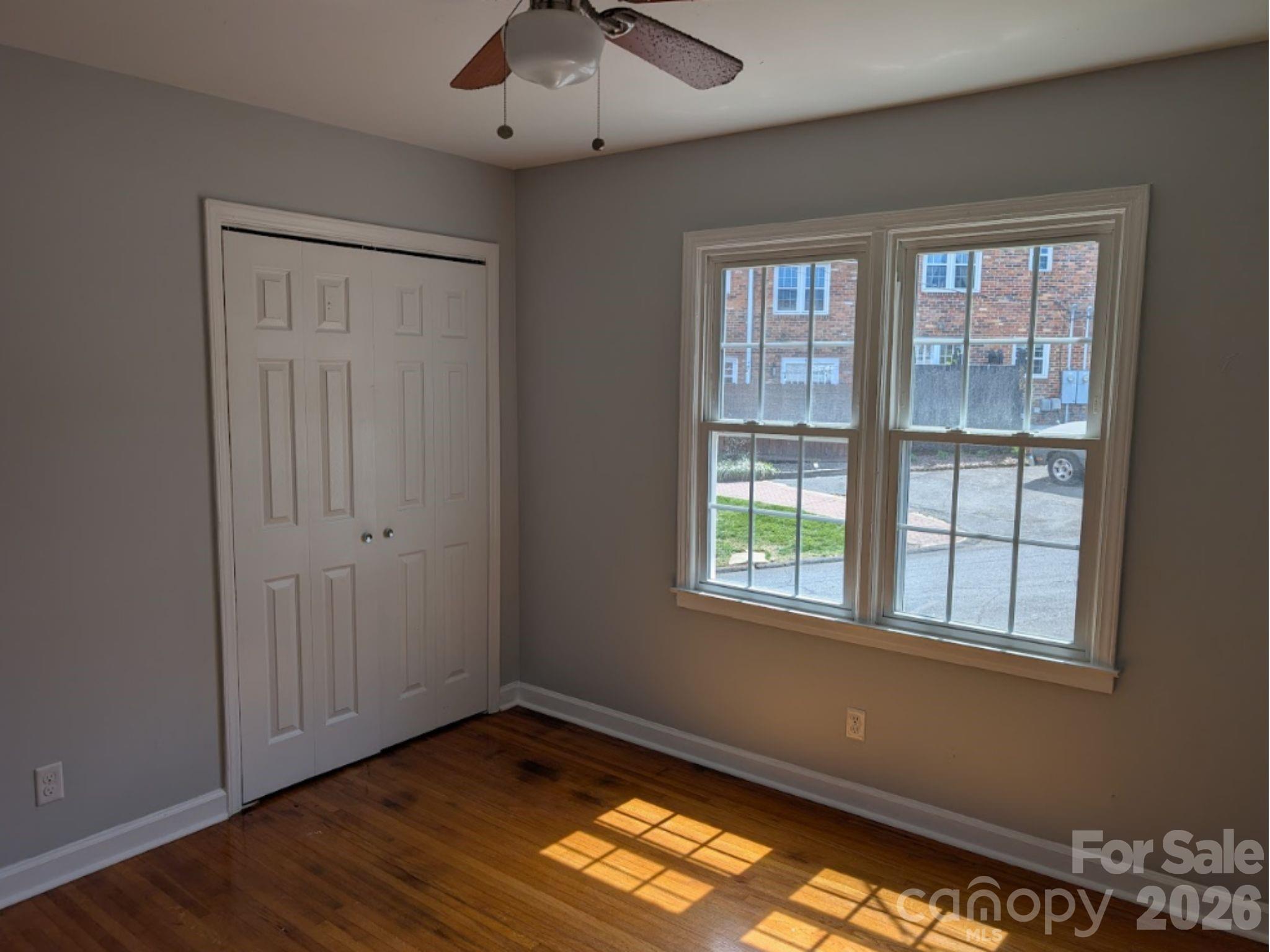 910 McAlway Road, Unit C Charlotte, NC 28211 - Photo 7 of 13 a view of an empty room with a window and wooden floor