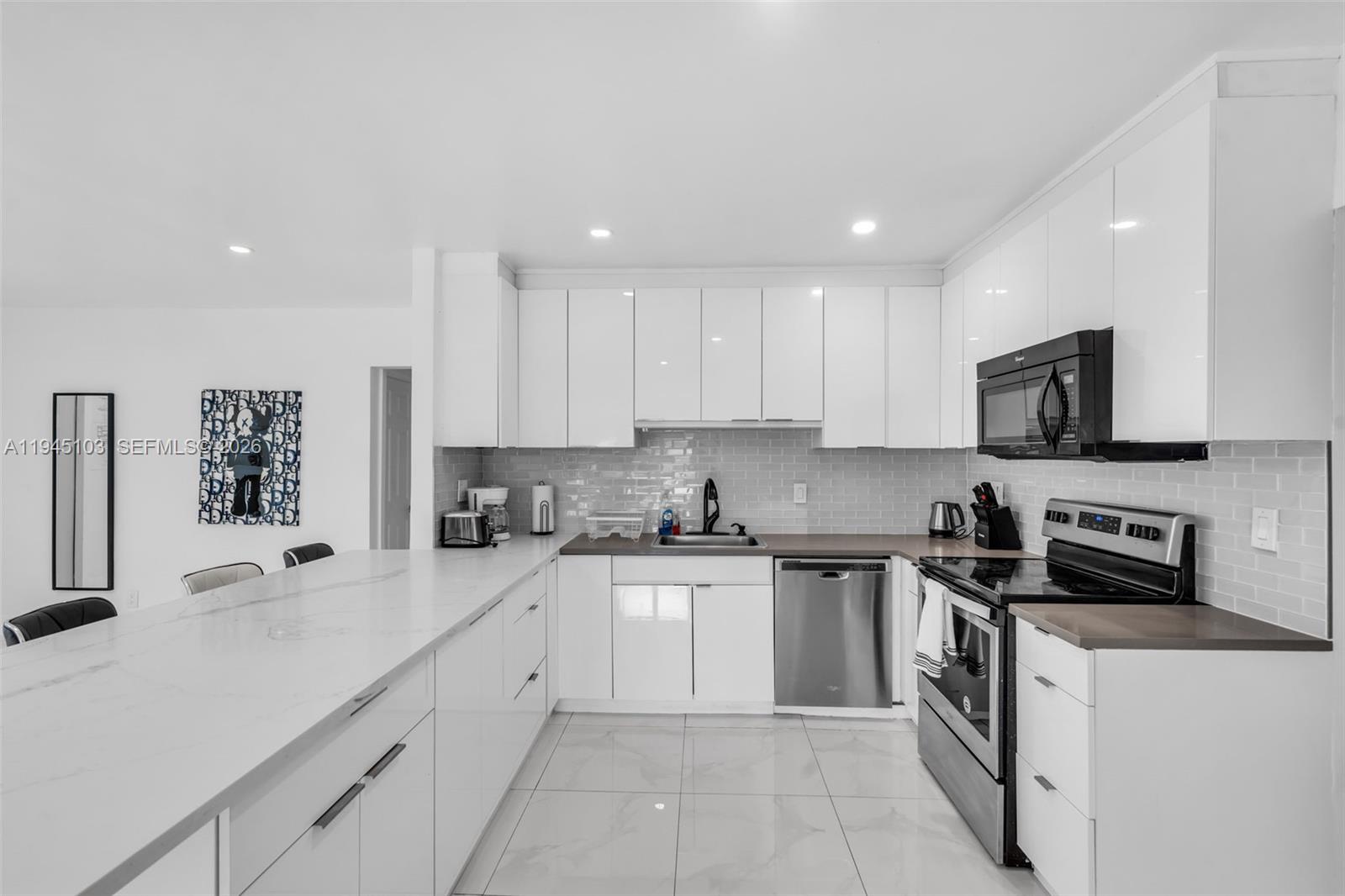 2721 Harding Street Hollywood, FL 33020 - Photo 13 of 38 a kitchen with a sink a stove and cabinets