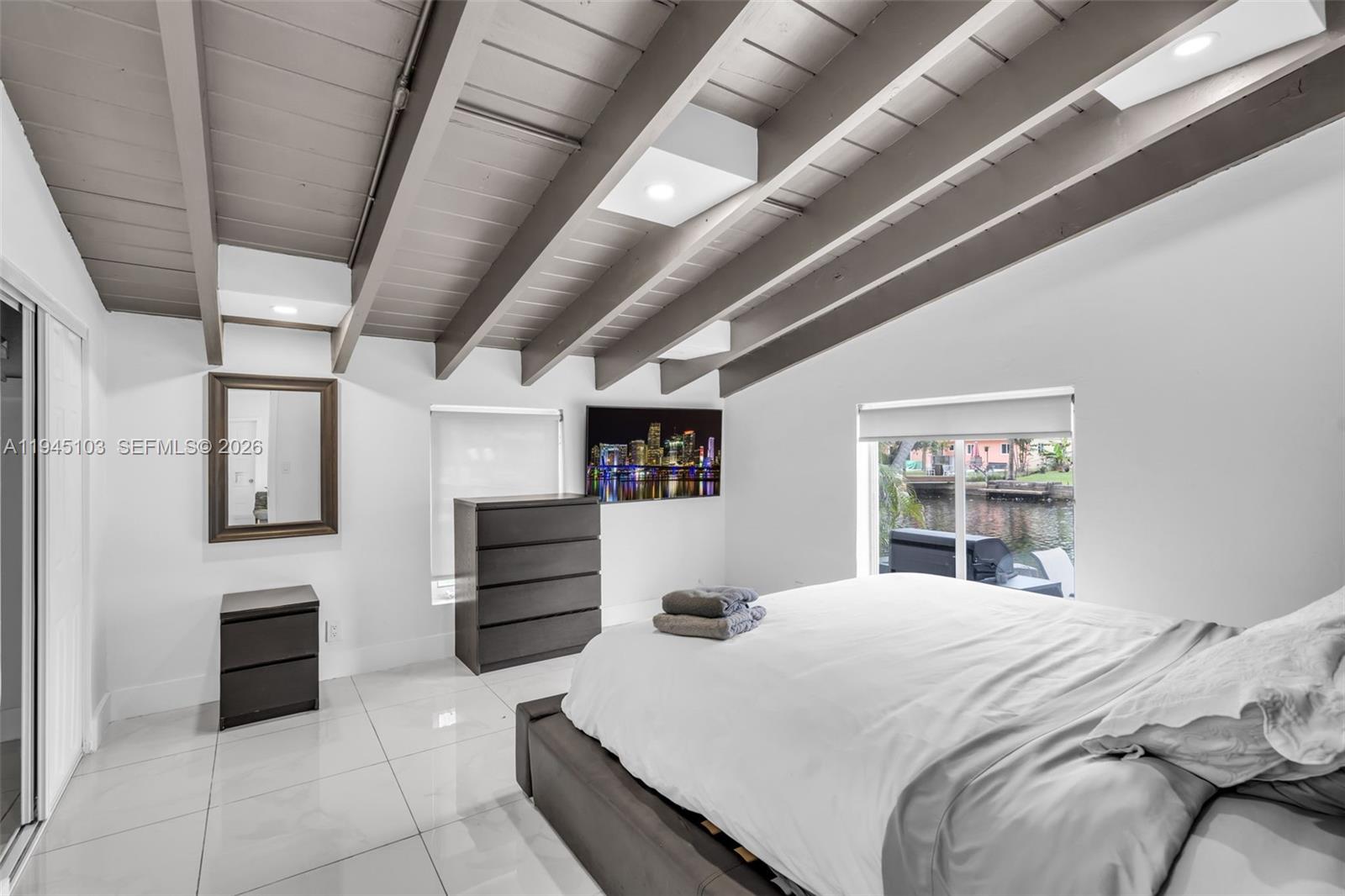 2721 Harding Street Hollywood, FL 33020 - Photo 17 of 38 a bedroom with a bed and dresser with mirror