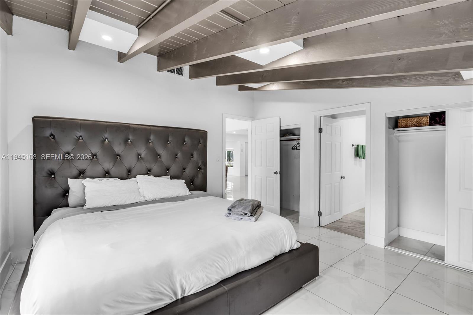 2721 Harding Street Hollywood, FL 33020 - Photo 21 of 38 a bedroom with a large bed and a chandelier