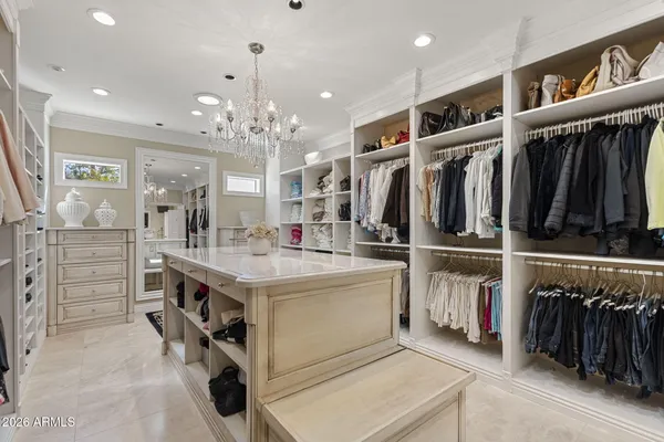 a spacious bedroom with a bed a dresser and a flat screen tv