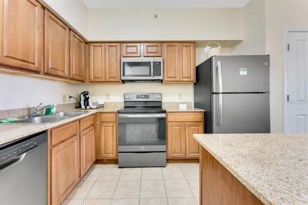 a kitchen with a sink a refrigerator and a stove top oven