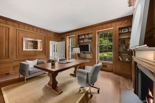 a living room with furniture a fireplace and large windows