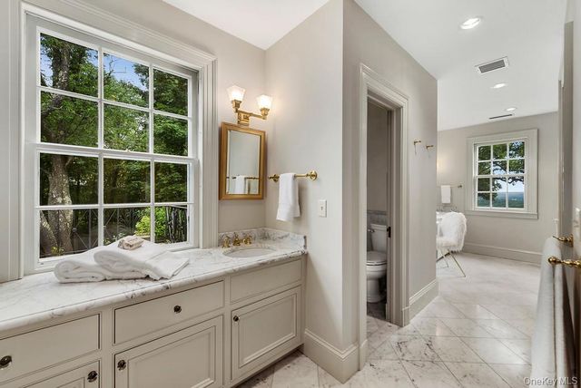 a bathroom with a granite countertop sink a mirror and a shower