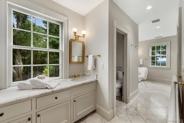 a bathroom with a granite countertop sink a mirror and a shower
