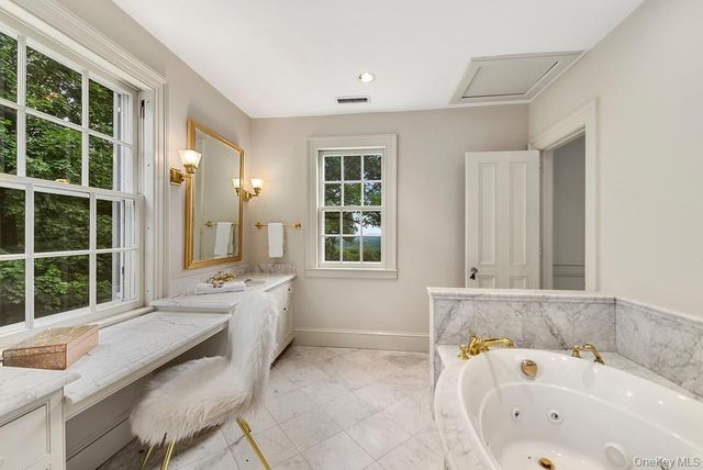 a bathroom with a tub sink and mirror