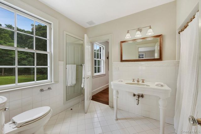 a bathroom with a toilet a sink and mirror