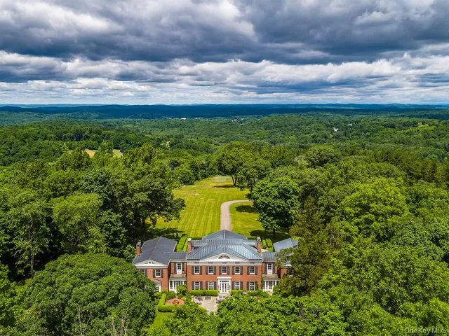aerial view of a house with a big yard and large trees