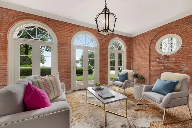 a living room with furniture a table and a large window