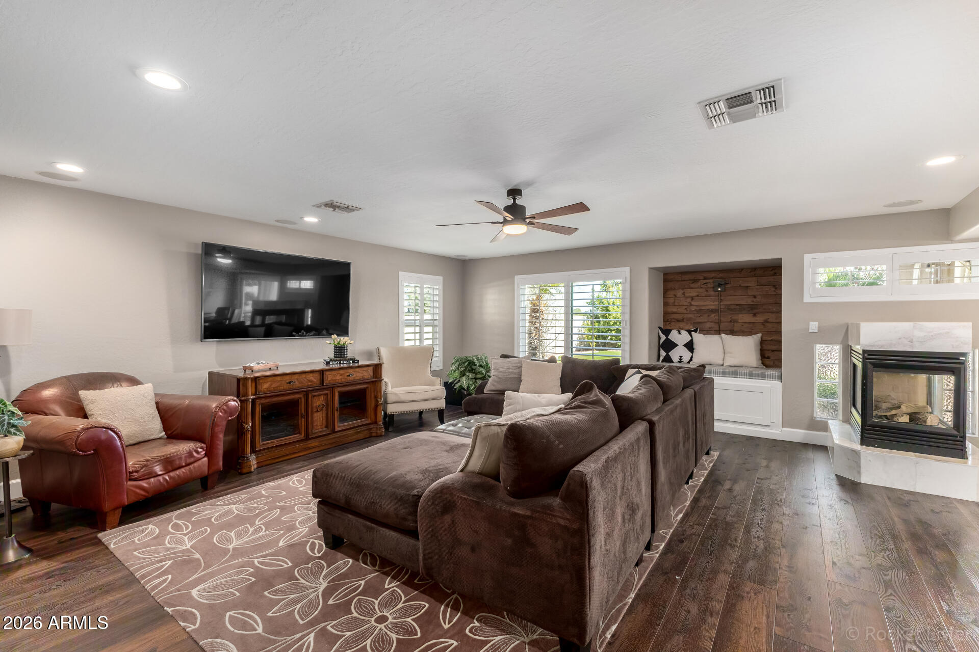 2611 East Catclaw Street Gilbert, AZ 85296 - Photo 8 of 29 a living room with furniture flat screen tv and a fireplace