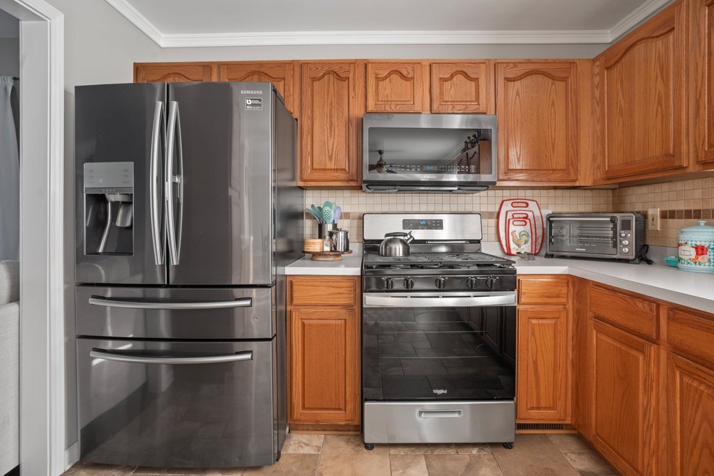 232 Stamford Lane Romeoville, IL 60446 - Photo 11 of 48 a kitchen with stainless steel appliances granite countertop a refrigerator stove and microwave