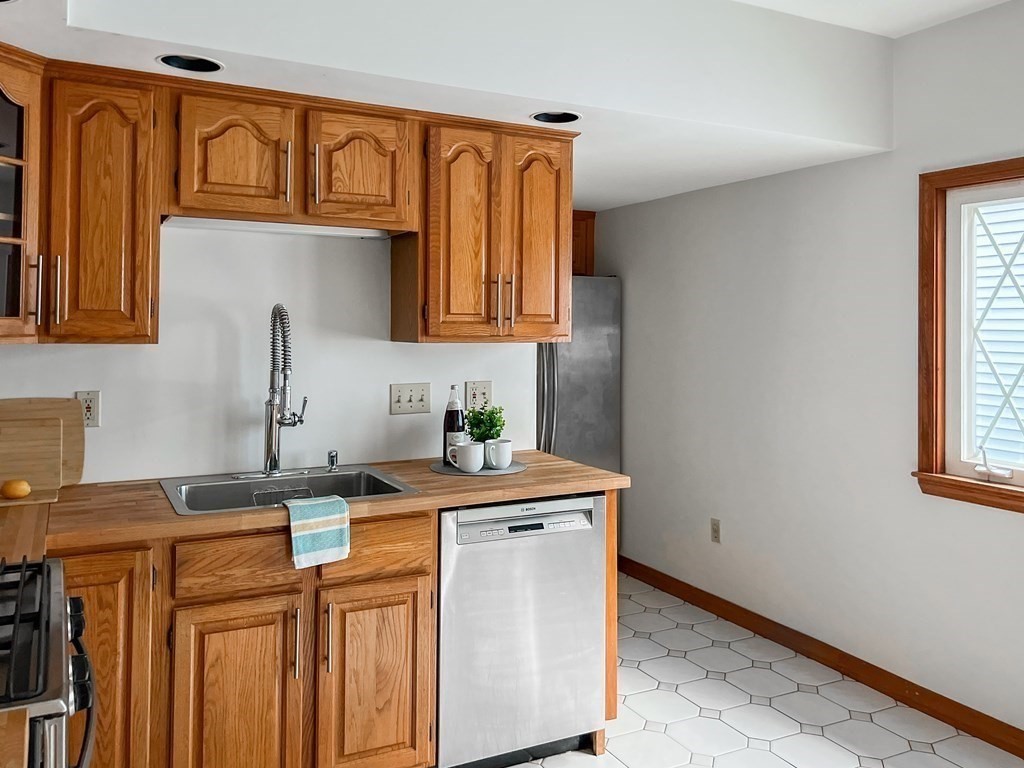 7 Gorham Road Medford, MA 02155 - Photo 11 of 42 a kitchen with stainless steel appliances granite countertop a sink stove and cabinets