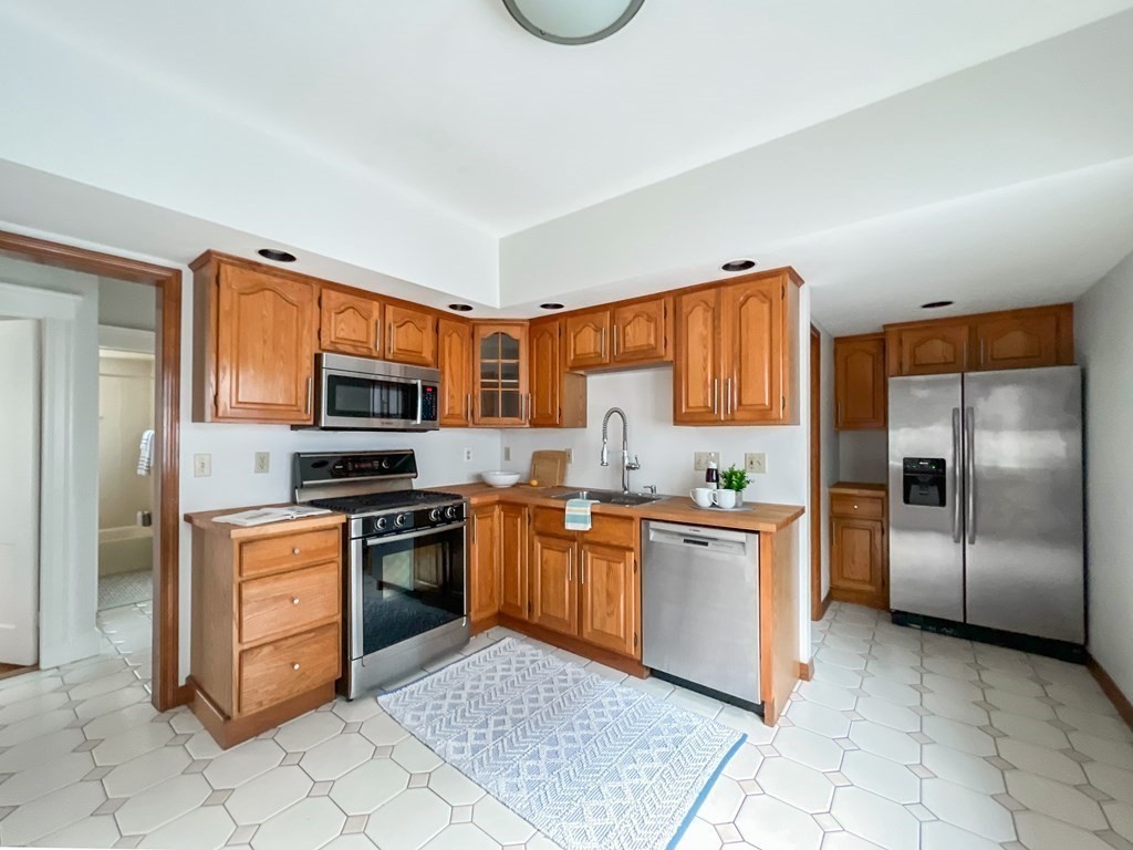 7 Gorham Road Medford, MA 02155 - Photo 9 of 42 a kitchen with stainless steel appliances granite countertop a stove top oven a refrigerator a sink and dishwasher