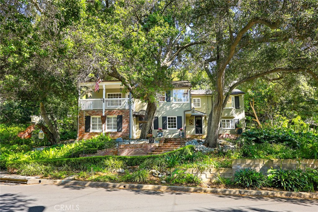 a front view of a house with a yard and tree s