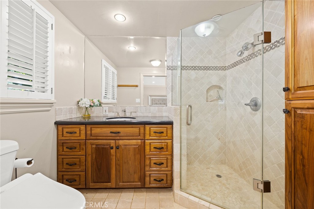 8 Hidden Valley Road Monrovia, CA 91016 - Photo 22 of 45 a bathroom with a granite countertop sink a mirror a vanity and a shower